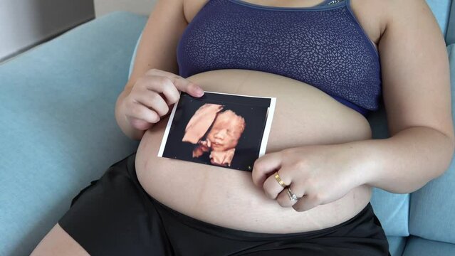 Pregnant woman holding baby Photos