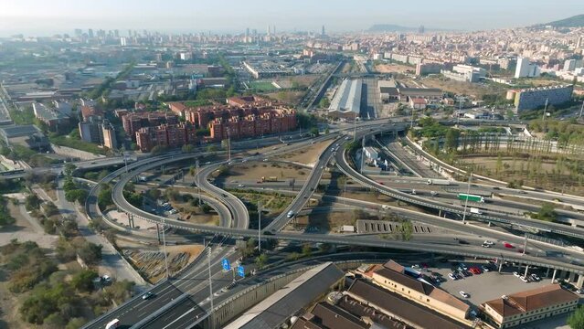 Aerial drone view of cars drive on a  cross road. Nus de la Trinitat traffic. Cityscape of the city of Barcelona, Catalonia, Spain.
Traffic highway transportation.
Ronda de Dalt, Ronda Litoral.