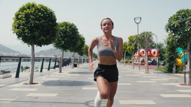Young caucasian woman running in park sprinting exercising intense cardio workout. High quality 4k footage