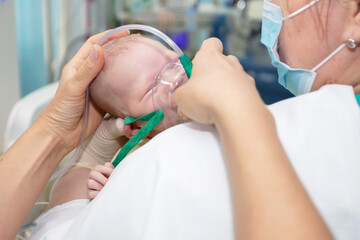 Baby with an oxygen mask in the neonatal unit.Baby wear oxygen mask - obrazy, fototapety, plakaty