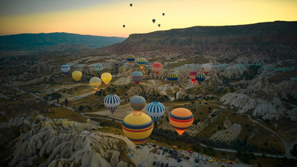 Lots of hot air balloons above fairy chimneys rock formations. Aerial view of Cappadocia. Goreme,...