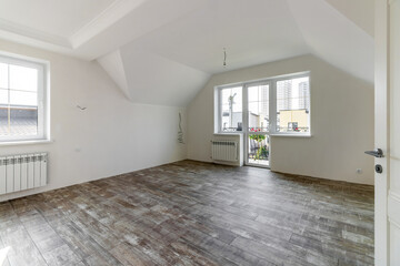 A room in a private house immediately after laying the floor, white unfinished walls and ceiling