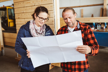 Carpenter Explaining House Plan to Homeowner