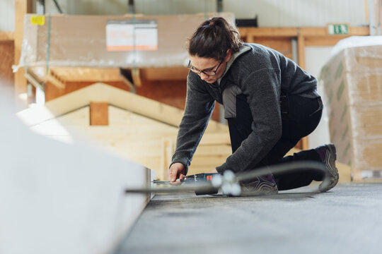 Female Carpenter Sketching in the Production Hall