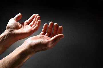Praying man hands with hands up isolated dark