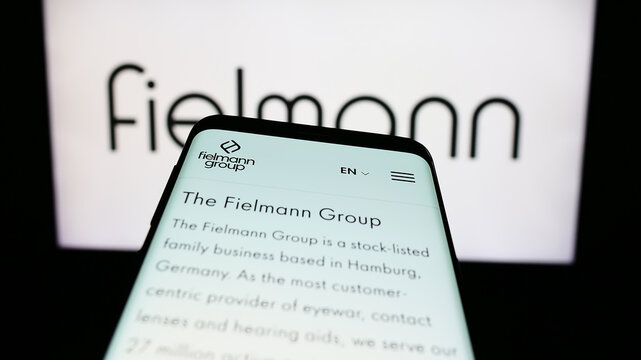 Stuttgart, Germany - 08-21-2023: Mobile phone with website of German eyewear company Fielmann AG on screen in front of business logo. Focus on top-left of phone display.
