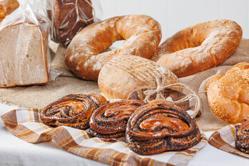 Closeup Buns with poppy seeds. Different types of artisan craft bread in bakery store shelves
