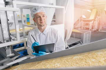 Worker man control quality product on automatic conveyor belt for transporting cedar nuts. Concept...