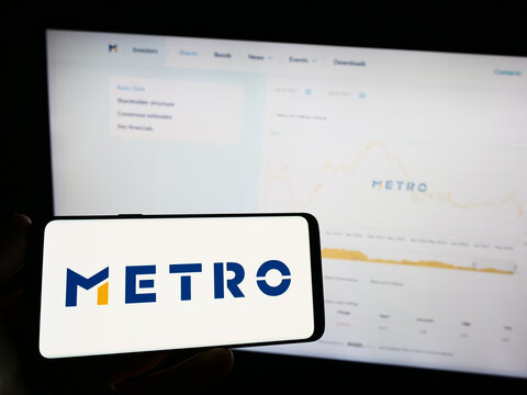 Stuttgart, Germany - 08-22-2023: Person holding mobile phone with logo of German wholesale company Metro AG on screen in front of business web page. Focus on phone display.