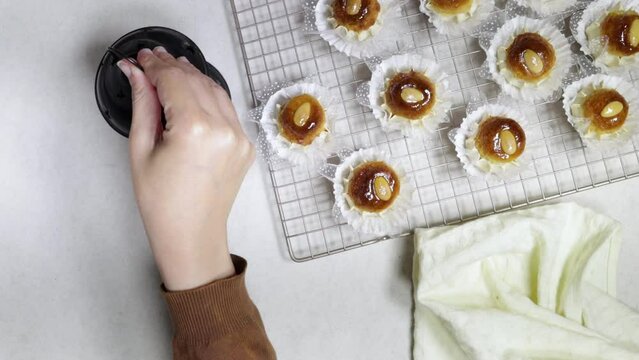 Oriental Algerian sweet cookies named dziriettes in Arabic language on grill and woman hold lantern and rosary bead and heart toy