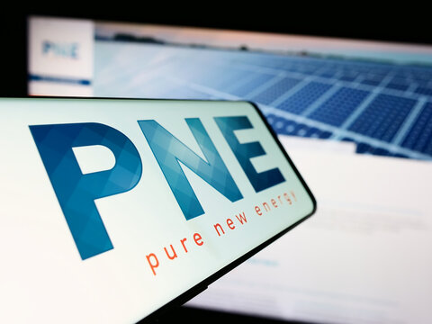 Stuttgart, Germany - 08-22-2023: Mobile phone with logo of German wind energy company PNE AG on screen in front of business website. Focus on center-left of phone display.