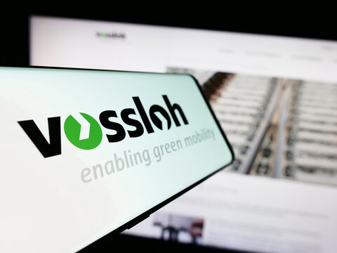 Stuttgart, Germany - 08-24-2023: Smartphone with logo of German rail technology company Vossloh AG on screen in front of business website. Focus on center-left of phone display.