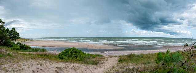 Landscape with Užava river and Baltic sea, the mouth of the river. Panoramic shot.
