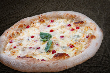 Pizza Four Cheese with smoked suluguni, gorgonzola, mozzarella, mountain ash, walnuts, honey, basil. Neapolitan round pizza on wood background