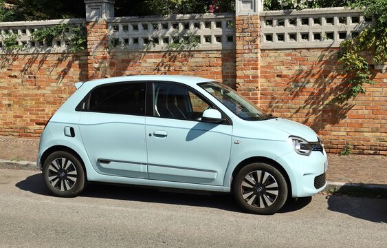 Udine, Italy. August 27, 2023  Light blue new Renault Twingo at the road side. Brick wall on background.	