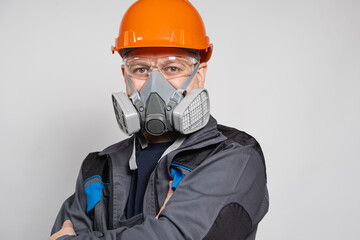 A man wearing a helmet, respirator and goggles on a white background