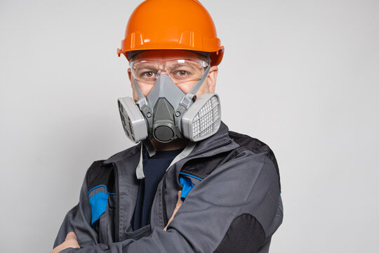 A Man Wearing A Helmet, Respirator And Goggles On A White Background