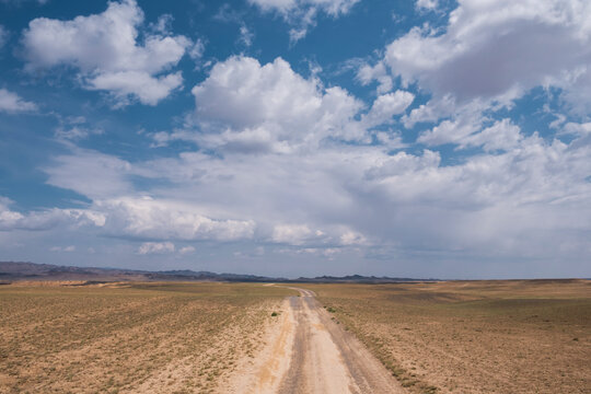 A country road in the summer under a clear blue sky - filmed in the steppes of Kazakhstan. View of the old road