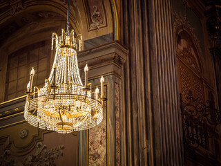 Photo of a stunning chandelier suspended from the ceiling, illuminating the grandeur of the building
