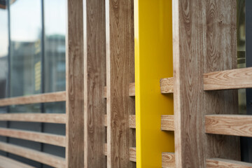 A fragment of the wall of a wooden cafe made of yellow boards. Wooden beams in the groove. A fragment of a wall at the intersection of several natural-colored boards. High quality photo