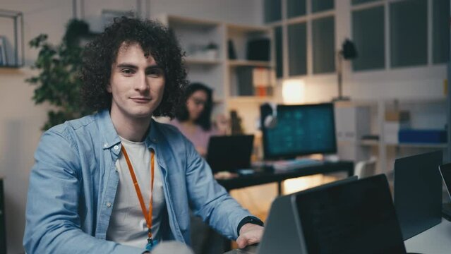 Portrait of young man working as IT specialist, testing software in office