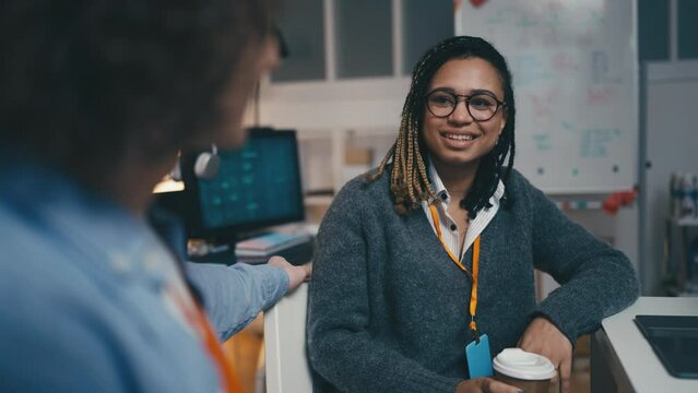 African American woman having conversation with a colleague in office, coworkers