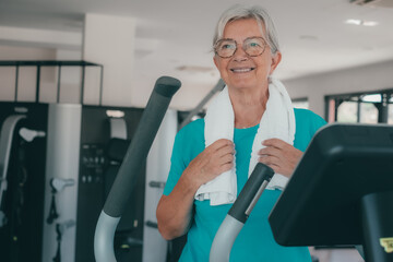 Active smiling senior woman doing exercises in the gym to stay fit and strengthen her muscles. Sport, healthy, gym, wellness concept