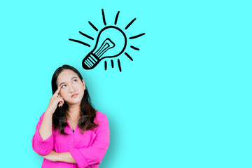 Thoughtful Asian woman keeps hand on forehead looks pensively with drawing of light bulb above the head
