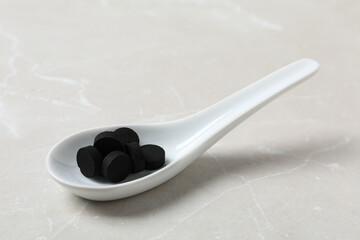 Activated charcoal tablets in a white spoon