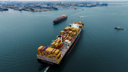 aerial view rear of cargo container ship carrying in sea import export goods and distributing products to dealer consumers, global business transportation by container ship open sea,