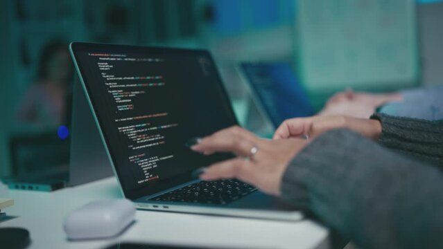 Closeup of programmers working on laptops, people creating programs in office