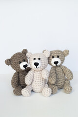 Crocheted gray and brown bears on a white background. Crocheted toy.