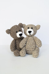 Crocheted gray and brown bears on a white background. Crocheted toy.