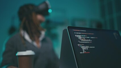 Young woman game designer developing VR game, testing features in a headset - Powered by Adobe