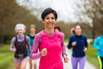 Woman leading a group of runners training in nature