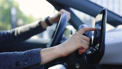 Side view of unrecognizable business man which typing needed coordinates on navigator touchscreen inside his auto. Man sitting in front of the handlebar of his own luxury auto and applying navigator