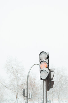 Yellow traffic light on snowy road
