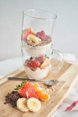 Delicious dessert served with strawberry and banana slices on table