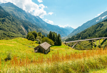 Fototapeta premium Alpine mountains in summer. View of the bridge and the valley