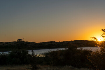 evening in the desert land with a sun set and a lake