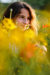 Naklejka premium Girl smelling flower in meadow