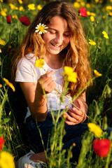 Fototapeta premium Smiling girl with flower relaxing in meadow