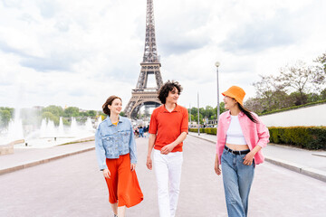 Group of young happy friends visiting Paris and Eiffel Tower - Multiethnic teens bonding outdoors...