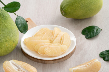 Fresh pomelo fruit on wooden table background.