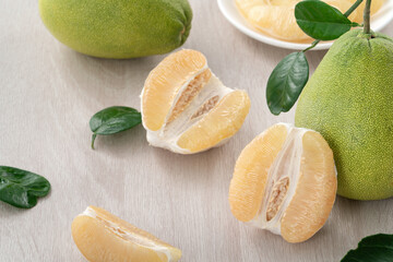 Fresh pomelo fruit on wooden table background.