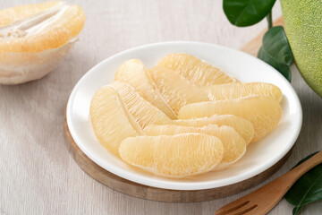 Fresh pomelo fruit on wooden table background.