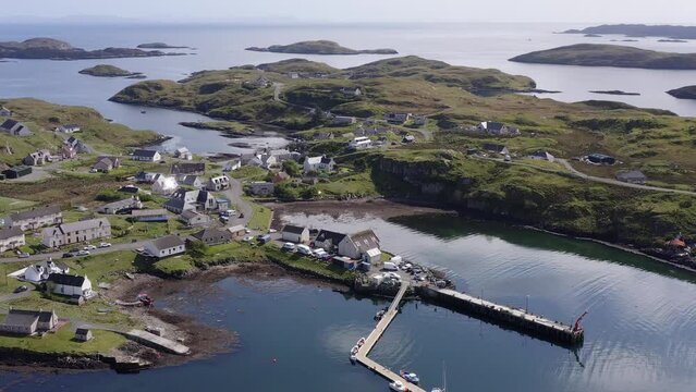 Drone shot circumnavigating the Isle of Scalpay, an island near the Isles of Harris and Lewis on the Outer Hebrides of Scotland. The Minch sea is visible in the background.