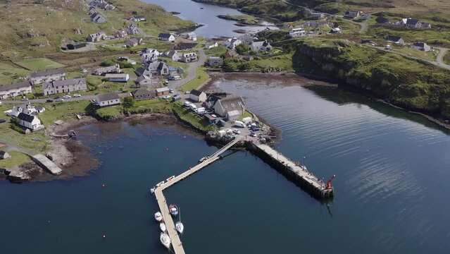 Advancing and tilting drone shot of the Isle of Scalpay, an island near the Isles of Harris and Lewis on the Outer Hebrides of Scotland. The Minch sea is visible in the background.