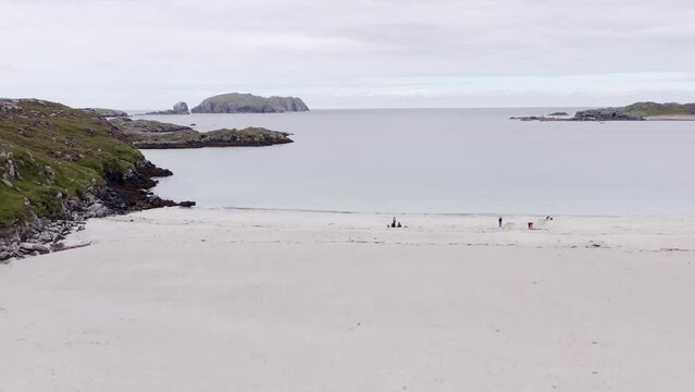 Ascending drone shot of Bosta beach on the Isle of Great Bernera, near the Isle of Lewis on the Outer Hebrides of Scotland. The horizon, ocean, hills, moorland and peatland are visible.