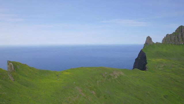 Drone Pan of cliffs and green valley in the remote trekking location of hornstrandir, Iceland, in the Arctic Circle 